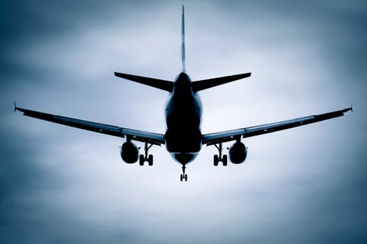 silhouette passenger jet on takeoff or landing through soft focus clouds