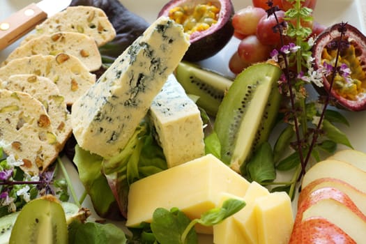 Delicious fruit and cheese platter featuring a variety of different cheeses and fresh fruits.