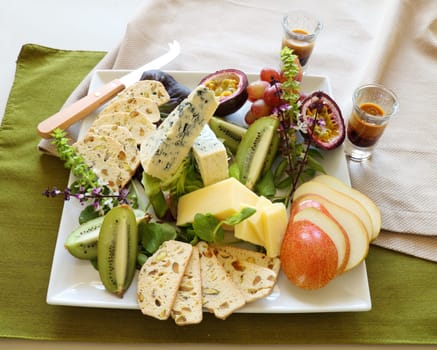 Delicious fruit and cheese platter featuring a variety of different cheeses and fresh fruits.