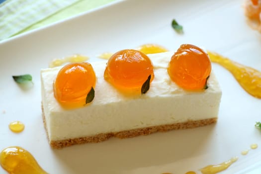 Delicious mandarin cheese cake with mandarin balls and a fruit sauce.