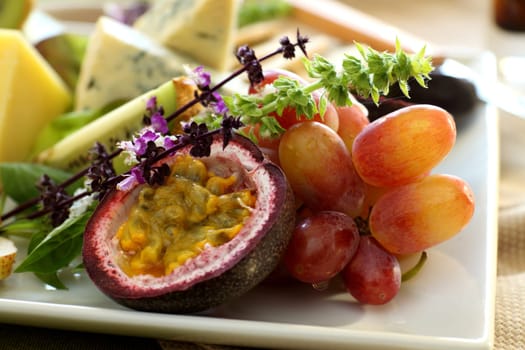 Delicious passionfruit with fresh grapes, basil flowers and a variety of cheeses.