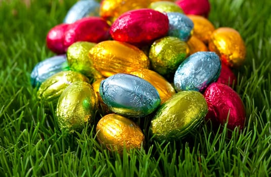 Close-up on chocolate Easter eggs on grass.