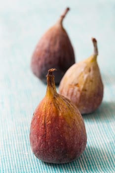 Delicious fresh figs on a blue background. Studio shot.