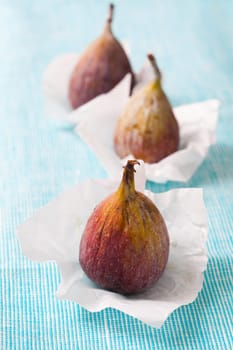 Delicious fresh figs on a blue background. Studio shot.