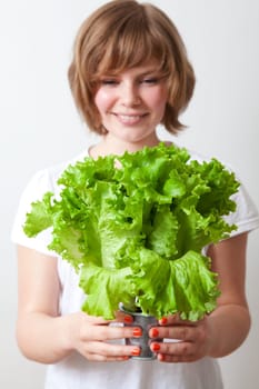 Young caucasian woman holding fresh green lettuce