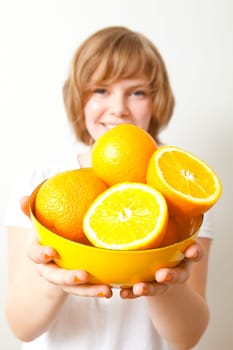 Young woman holding a bowl of fresh oranges. Studio shot.