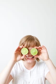 Woman with fresh limes, holding them in front of her eyes