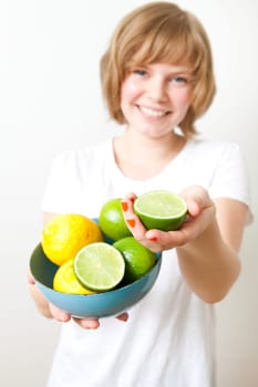 Young woman holding a bowl of fresh lemon and lime