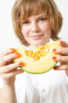 Young woman holding a piece of fresh cantaloupe melon