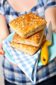 Woman holding a plate of fresh bread