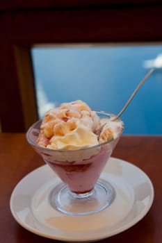 A delicious bowl of strawberry ice cream with whipped cream on top.