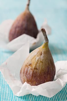 Delicious fresh figs on a blue background. Studio shot.