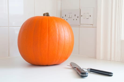 Preparing Halloween, a pumpkin and two knives in a kitchen