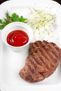 Juicy roasted beef steak with vegetables closeup at plate
