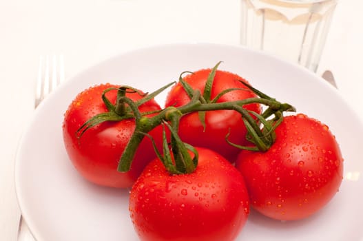 Diet - Fresh Tomatoes, Cutlery and Glass of Water on the Table