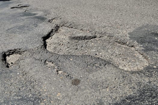 road destroyed after winter. a hole in the road.