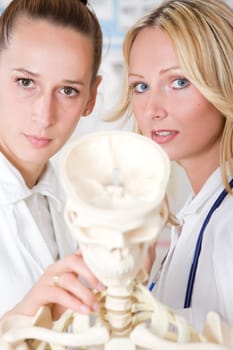 two women medicine students with skeleton