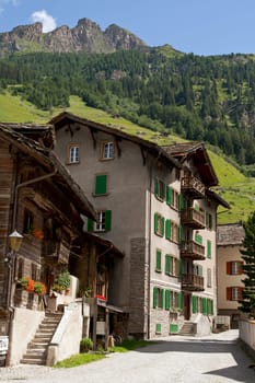 Swiss houses in front of a mountain panorama