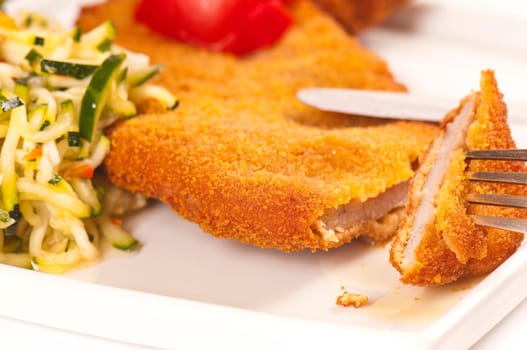 Schnitzel with tomato slices and zucchini salad