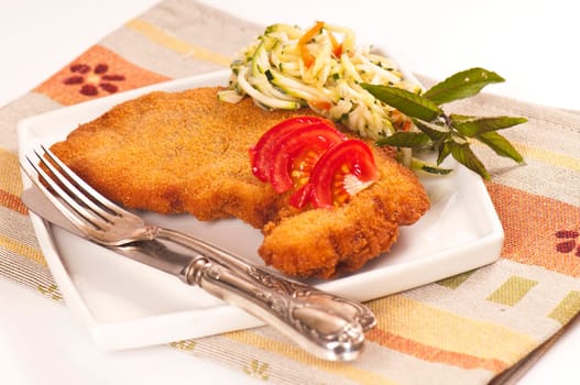 Schnitzel with tomato slices and zucchini salad