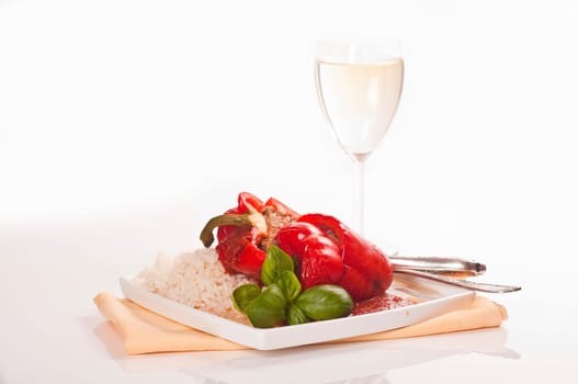 stuffed red peppers with rice and herbs served on plates with wine glass
