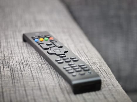 closeup of television remote control on sofa. Horizontal shape, copy space