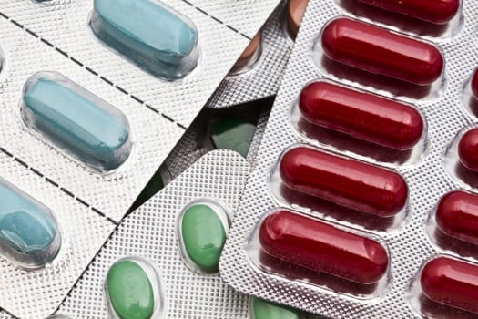 Background of colorful capsules and pills closeup