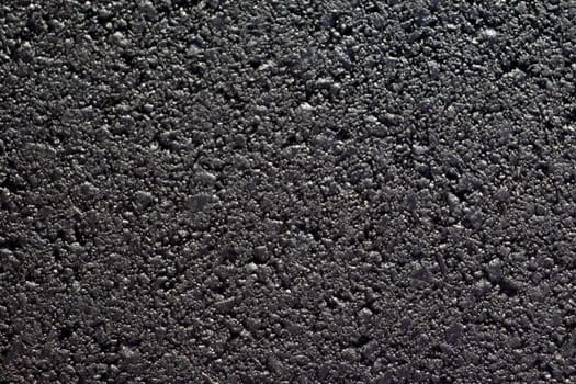 Close up background of a newly paved black asphalt blacktop street.