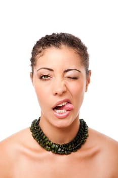 Funny face of a beautiful attractive fashion model sticking out tongue while winking, wearing green necklace, isolated.