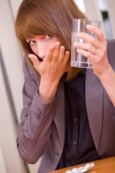 young business woman taking medicine by office work
