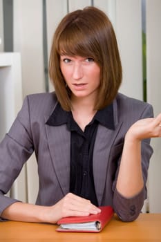 young businesswoman or secretary with diary in stress by office work