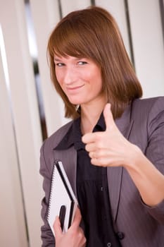 happy businesswoman with thumb up in office