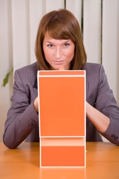 thinking businesswoman with file card holder in office