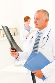 Medical doctor team senior man with female nurse look x-ray