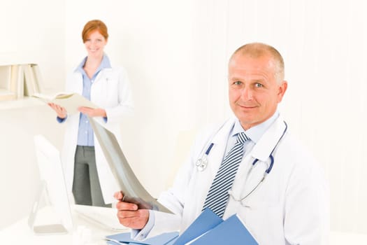 Medical doctor team senior man with female nurse hold x-ray
