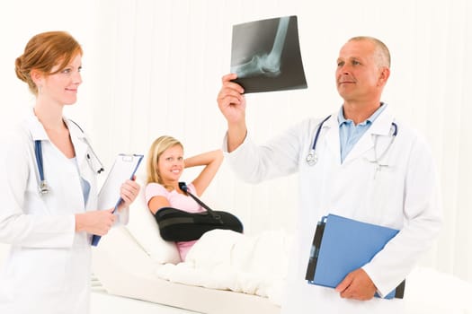 Medical doctors look at x-ray hospital patient in bed broken arm