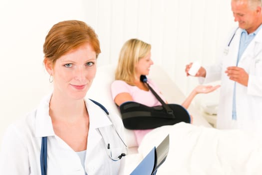 Medical doctors give pills hospital patient in bed broken arm