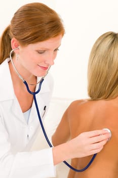 Medical professional doctor with stethoscope examine woman patient naked back