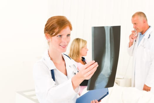 Medical doctors look at x-ray hospital patient in bed broken arm