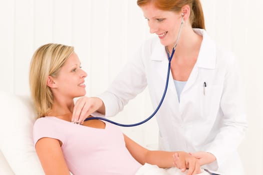 Medical professional doctor stethoscope examine woman patient lying in bed