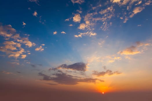 Evening sunset sky with sun and dramatic clouds