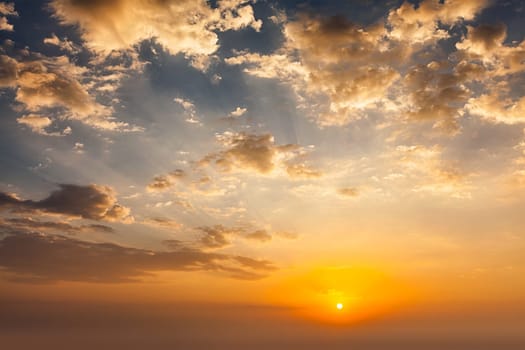 Evening sunset sky with sun and dramatic clouds