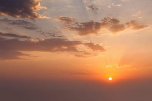 Evening sunset sky with sun and dramatic clouds