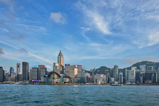 HONG KONG, CHINA - MAY 1, 2018: Hong Kong skyline cityscape downtown skyscrapers over Victoria Harbour in the day time with clouds. Hong Kong, China. Horizontal camera panning