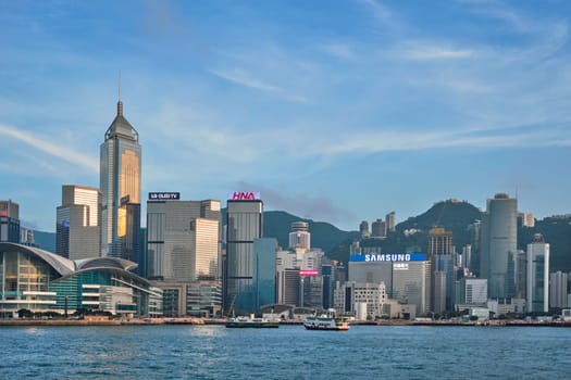 HONG KONG, CHINA - MAY 1, 2018: Hong Kong skyline cityscape downtown skyscrapers over Victoria Harbour in the day time with clouds. Hong Kong, China. Horizontal camera panning