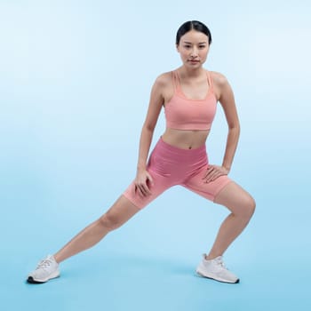 Young attractive asian woman in sportswear stretching before fitness exercise routine. Healthy body care workout with athletic woman warming up on studio shot isolated background. Vigorous