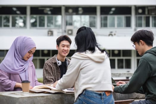 A multiracial group of students at the college, including Muslim and Asian students, sat on benches in a campus break area. Read books or study for exams together..