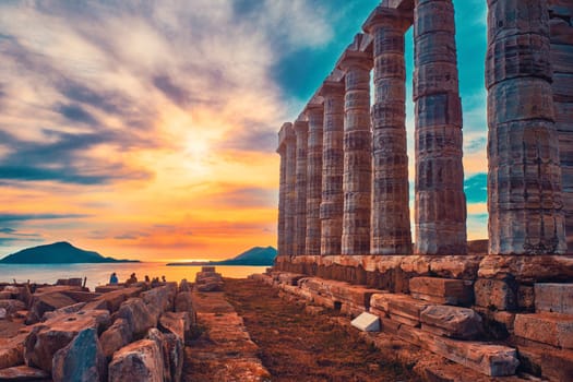 Greece Cape Sounio. Ruins of an ancient temple of Poseidon, Greek god of the sea, on sunset. Shot of temple ruins on sunset. Tourist landmark of Attica, Sounion, Greece