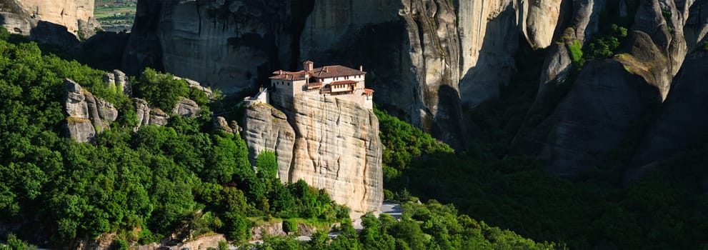 Panorama of Monastery of Rousanou in famous greek tourist destination Meteora in Greece on sunset with scenic landscape.