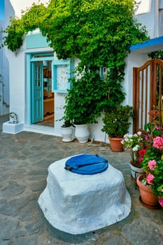 Greek village typical view with whitewashed houses and flowers in pots. Plaka town, Milos island, Greece